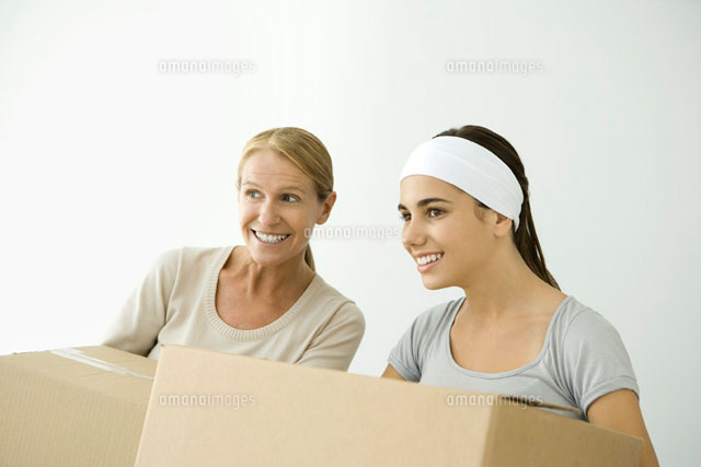 Mother and daughter holding cardboard boxes and looking away
(c)Alix Minde/PhotoAlto