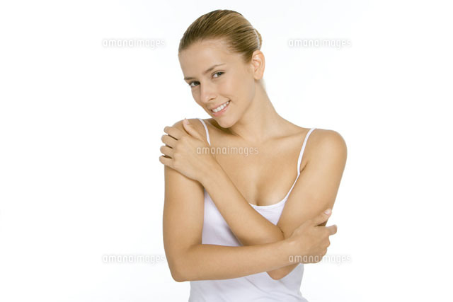 Woman in tank top touching shoulder and arm
(c)Alix Minde/PhotoAlto