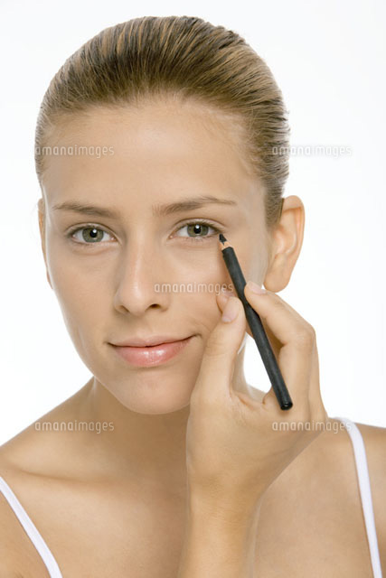 Woman applying eyeliner,smiling at camera,close,up
(c)Alix Minde/PhotoAlto
