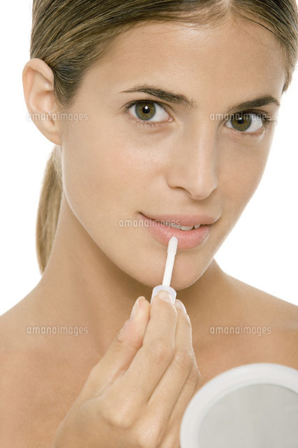 Woman putting on lip gloss
(c)Alix Minde/PhotoAlto