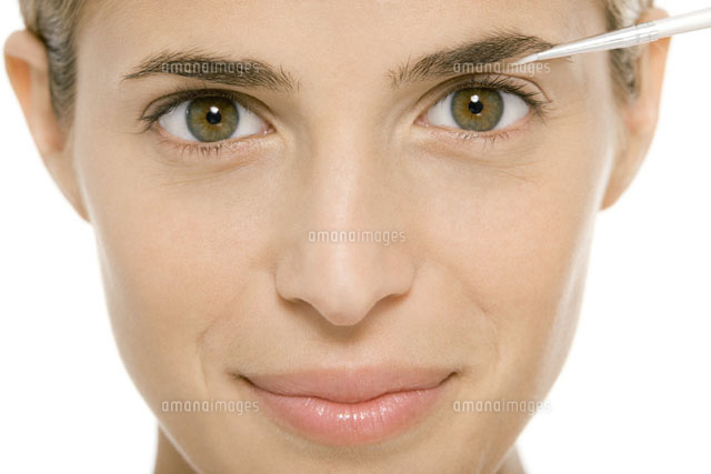 Woman applying make-up,smiling at camera
(c)Alix Minde/PhotoAlto