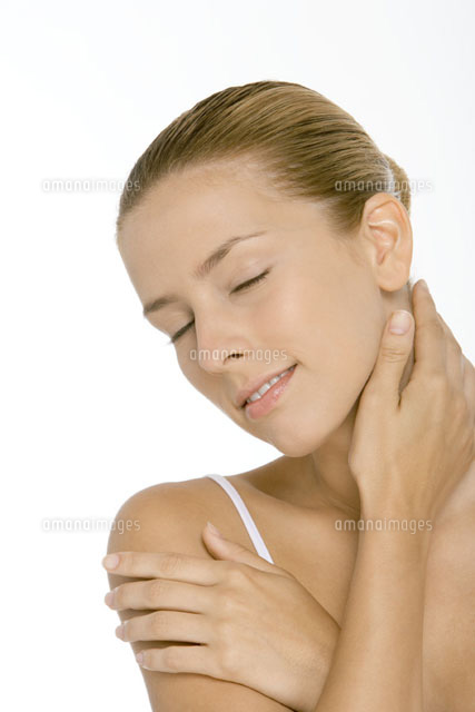 Young woman touching neck and shoulder,smiling
(c)Alix Minde/PhotoAlto