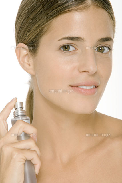 Woman putting on perfume,smiling at camera
(c)Alix Minde/PhotoAlto