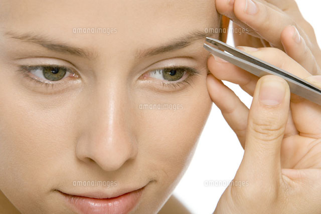 Woman using tweezers to pluck eyebrows,close-up
(c)Alix Minde/PhotoAlto