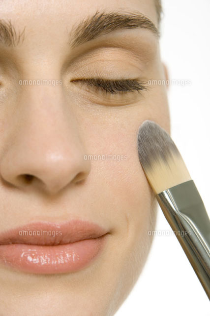 Woman putting on blush,smiling with eyes closed
(c)Alix Minde/PhotoAlto