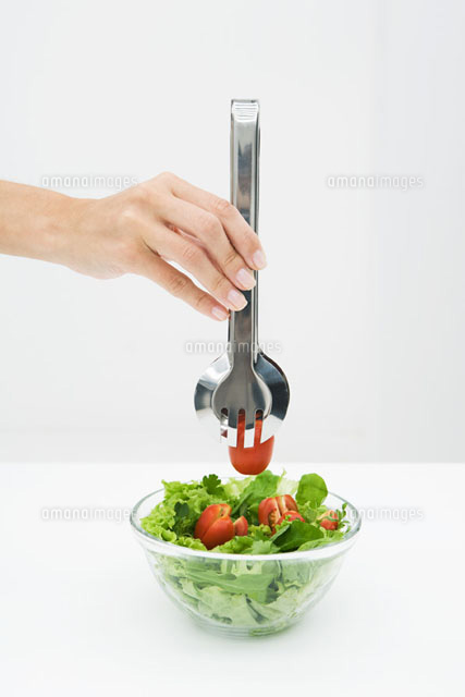 Woman picking tomato out of salad bowl using tongs
(c)Laurence Mouton/PhotoAlto