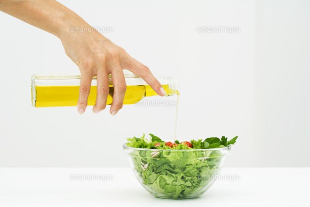 Woman pouring olive oil on salad,cropped view of hand
(c)Laurence Mouton/PhotoAlto