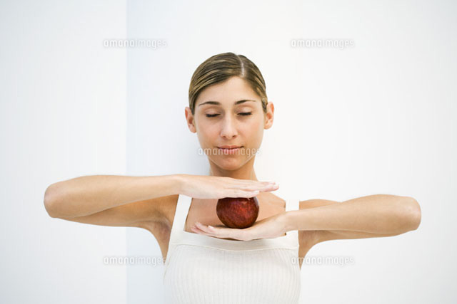 Woman balancing apple between hands,eyes closed
(c)Laurence Mouton/PhotoAlto