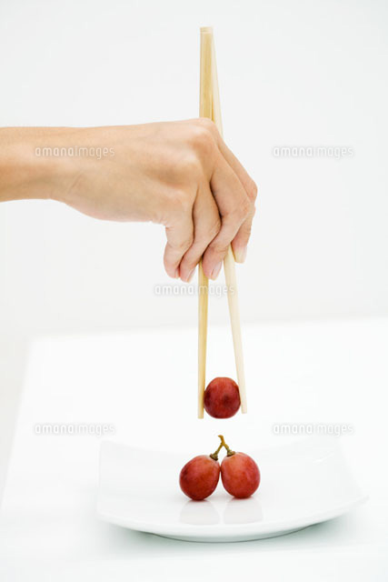 Woman picking up red grape with chopsticks
(c)Laurence Mouton/PhotoAlto