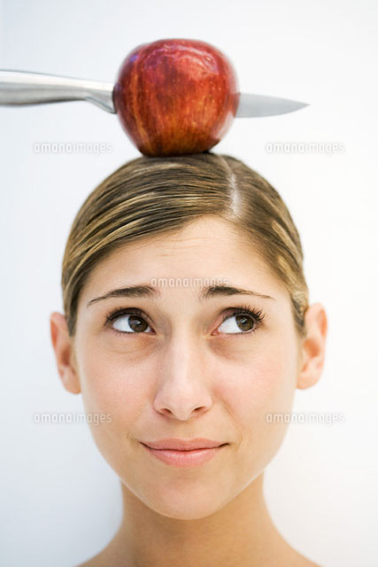 Young woman apple and knife on head,close-up
(c)Laurence Mouton/PhotoAlto