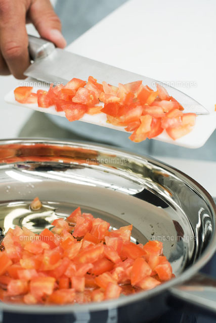 Man scraping diced tomatoes into saucepan with knife
(c)Laurence Mouton/PhotoAlto