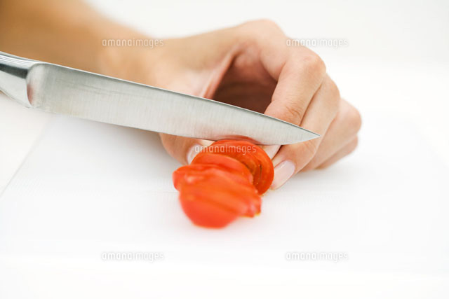 Woman slicing tomato with knife,cropped view of hand
(c)Laurence Mouton/PhotoAlto