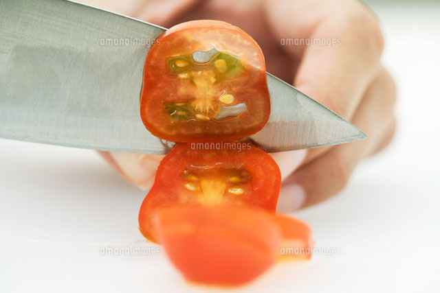 Woman slicing tomato with knife,cropped view of hand
(c)Laurence Mouton/PhotoAlto
