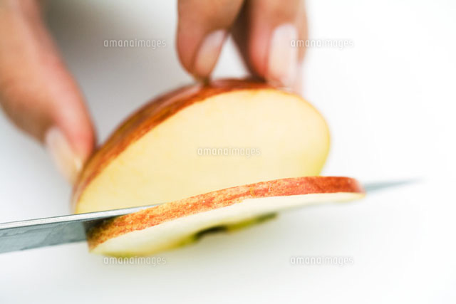 Woman slicing apple with knife,cropped view of hand
(c)Laurence Mouton/PhotoAlto