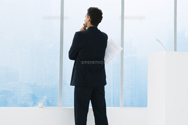 Businessman standing by window,holding document under arm
(c)Frederic Cirou/PhotoAlto