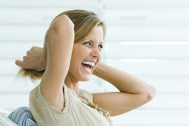 Woman pulling hair back with hands,laughing,side view
(c)Odilon Dimier/PhotoAlto