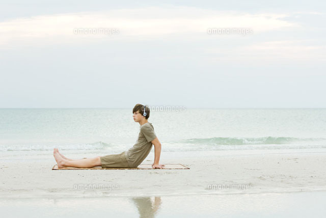 Teenage boy sitting on the beach,listening to headphones
(c)Odilon Dimier/PhotoAlto