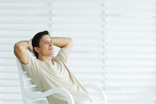 Man sitting in chair with hands behind head,looking away
(c)Odilon Dimier/PhotoAlto
