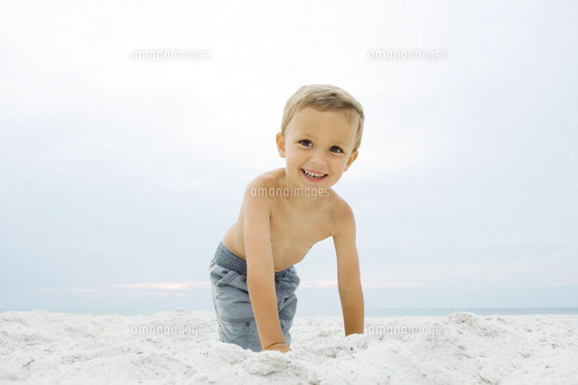 Boy crouching at the beach,smiling at camera
(c)Odilon Dimier/PhotoAlto