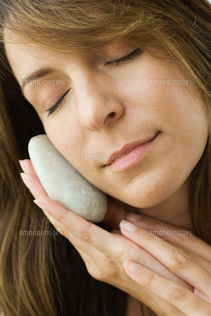 Woman holding smooth stone against cheek
(c)Odilon Dimier/PhotoAlto