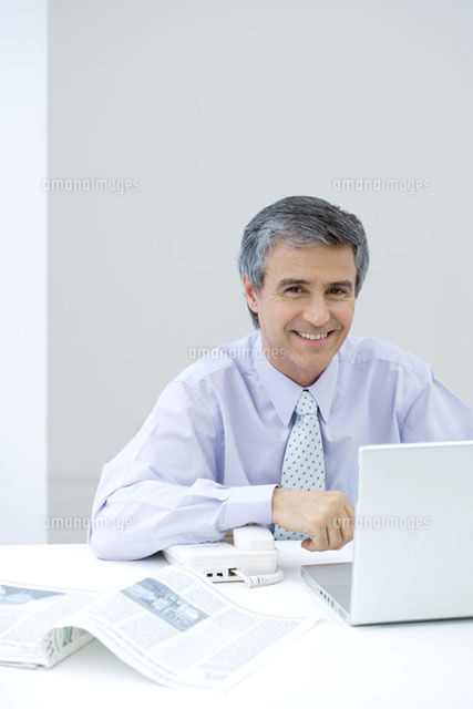 Businessman sitting at desk,smiling at camera
(c)Sigrid Olsson/PhotoAlto