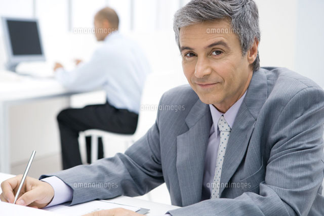 Businessman sitting at desk,using pen,smiling at camera
(c)Sigrid Olsson/PhotoAlto