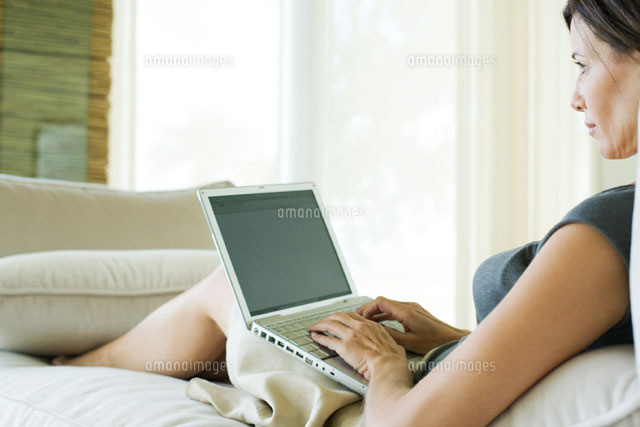 Woman reclining on sofa,using laptop computer
(c)Frederic Cirou/PhotoAlto