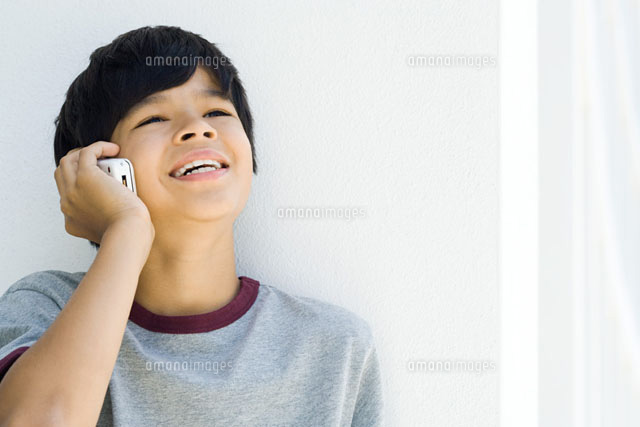 Boy using cell phone,looking up,smiling
(c)Frederic Cirou/PhotoAlto