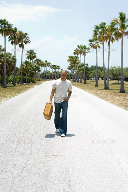 Man walking down center of road,carrying suitcase
(c)Frederic Cirou/PhotoAlto