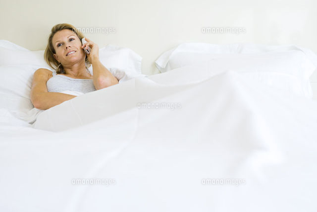 Woman lying in bed,talking on cell phone,looking away
(c)Frederic Cirou/PhotoAlto