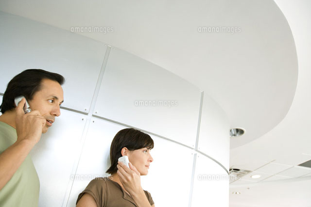 Man and woman indoors,both holding cell phone to ear
(c)Frederic Cirou/PhotoAlto