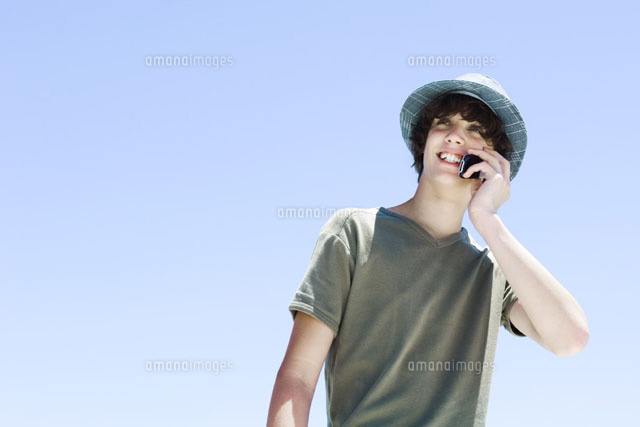 Teenage boy using cell phone,smiling,looking away
(c)Michele Constantini/PhotoAlto