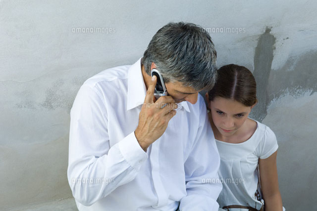 Father and daughter sitting together,man on cell phone
(c)Michele Constantini/PhotoAlto