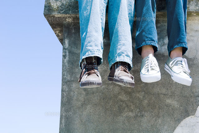 Two pairs of legs dangling over concrete ledge
(c)Michele Constantini/PhotoAlto