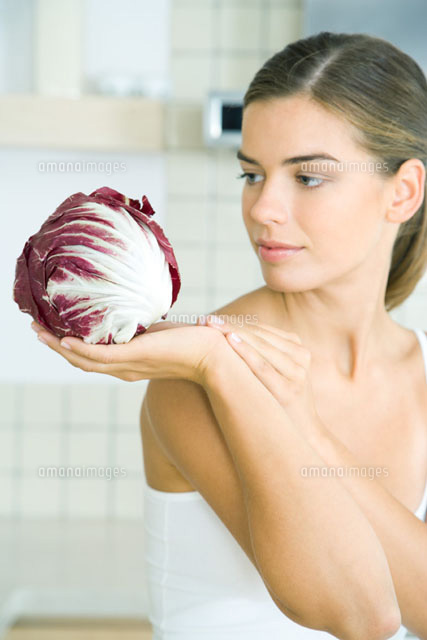 Woman looking at and holding a head of radicchio lettuce
(c)Rafal Strzechowski/PhotoAlto