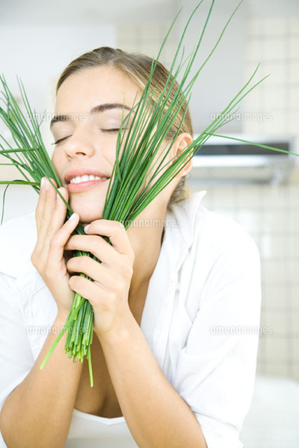 Young woman holding chives up to face,eyes closed
(c)Rafal Strzechowski/PhotoAlto