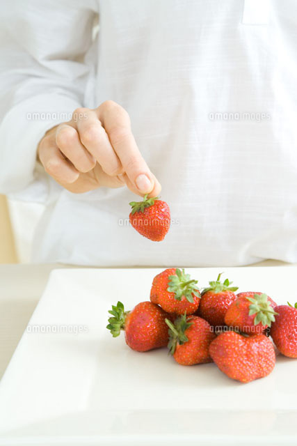 Hand picking up a strawberry from a pile on the counter
(c)Rafal Strzechowski/PhotoAlto