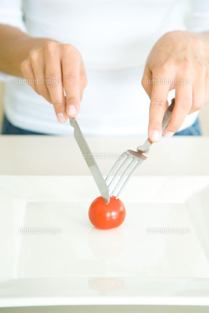 Woman cutting single cherry tomato with fork and knife
(c)Rafal Strzechowski/PhotoAlto