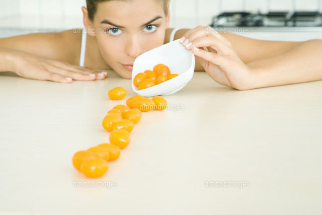 Woman spilling yellow cherry tomatoes out of a small dish
(c)Rafal Strzechowski/PhotoAlto