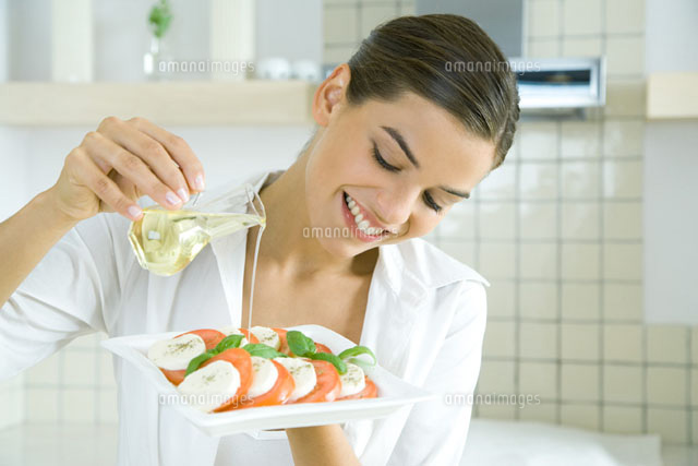 Young woman pouring olive oil over tomato mozzarella salad
(c)Rafal Strzechowski/PhotoAlto