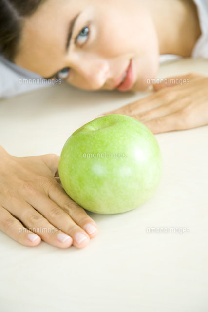 Woman resting head on counter behind apple
(c)Rafal Strzechowski/PhotoAlto