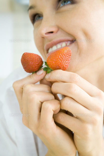 Woman holding a pair of strawberries,smiling
(c)Rafal Strzechowski/PhotoAlto