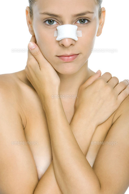 Woman with bandaged nose,arms folded across chest
(c)Alix Minde/PhotoAlto