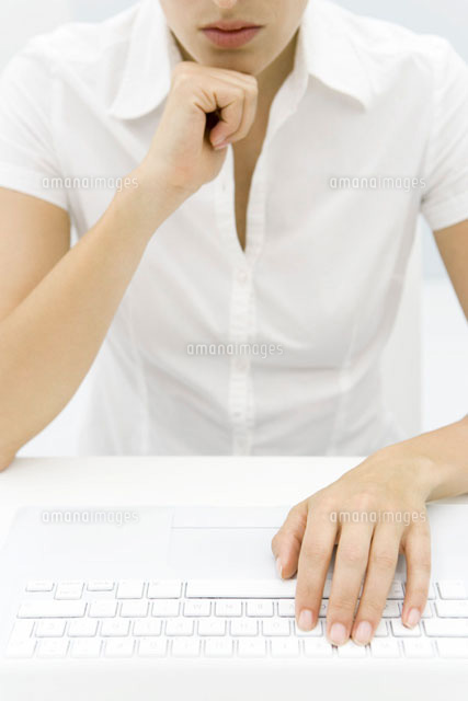 Woman in front of keyboard,hand under chin,cropped view
(c)Alix Minde/PhotoAlto