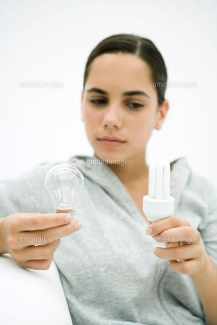Teen girl holding two kinds of light bulb,looking down
(c)Sigrid Olsson/PhotoAlto