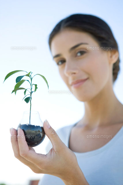 Woman holding potted seedling,smiling at camera
(c)Sigrid Olsson/PhotoAlto