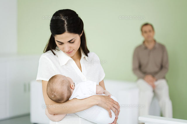 Woman holding sleeping baby,husband sitting in background
(c)Ale Ventura/PhotoAlto