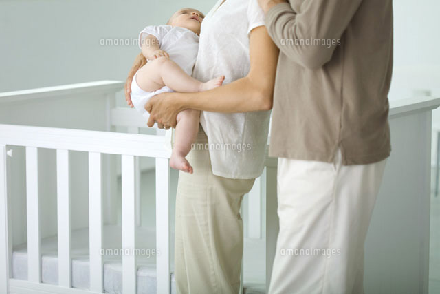 Parents standing beside crib,mother holding sleeping baby
(c)Ale Ventura/PhotoAlto
