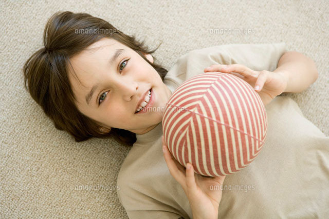 Boy lying on the ground,holding ball,smiling at camera
(c)Sigrid Olsson/PhotoAlto