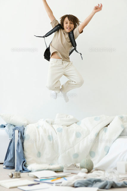 Boy jumping on bed in messy room,arms raised
(c)Sigrid Olsson/PhotoAlto